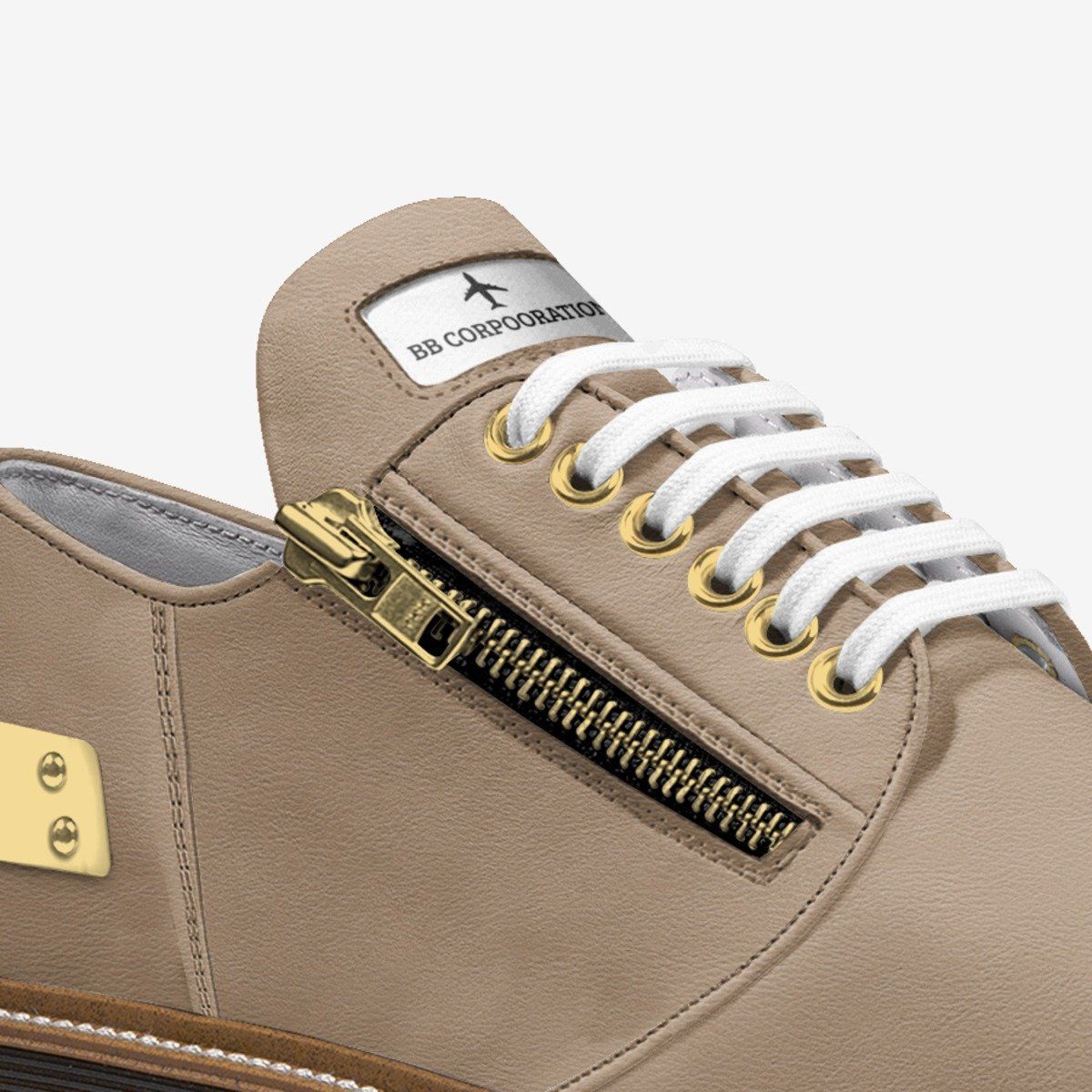 Tan leather shoe with gold zipper, white laces, and gold eyelets.