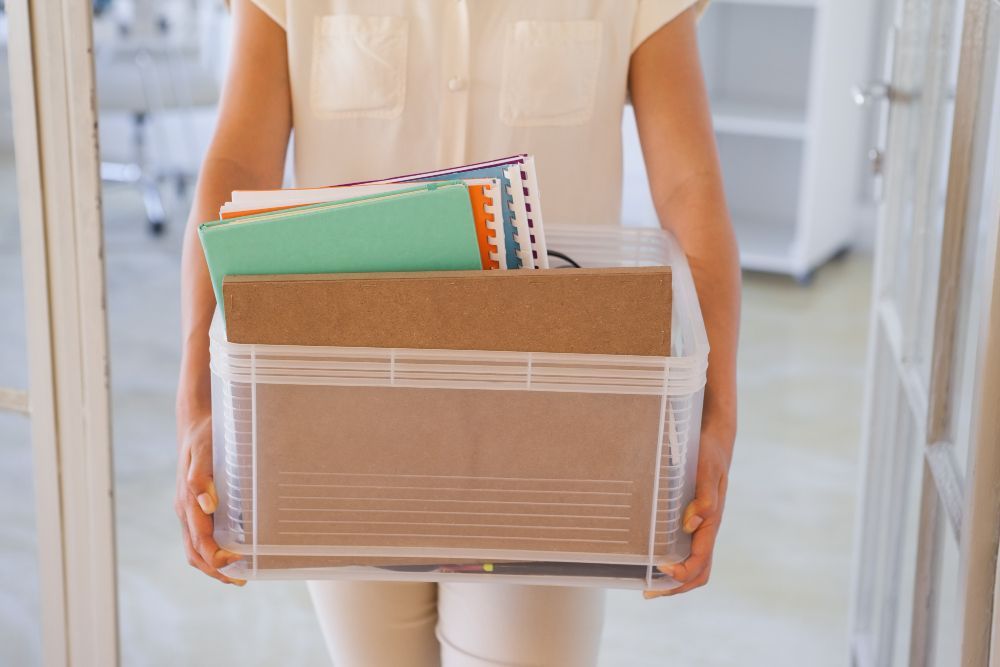 A woman is carrying a box full of her belongings.