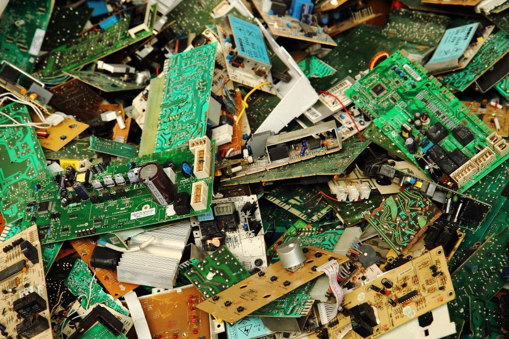 A pile of broken electronic components including a motherboard
