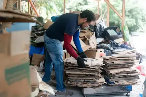 Man bundling paper at a site to drop off documents.
