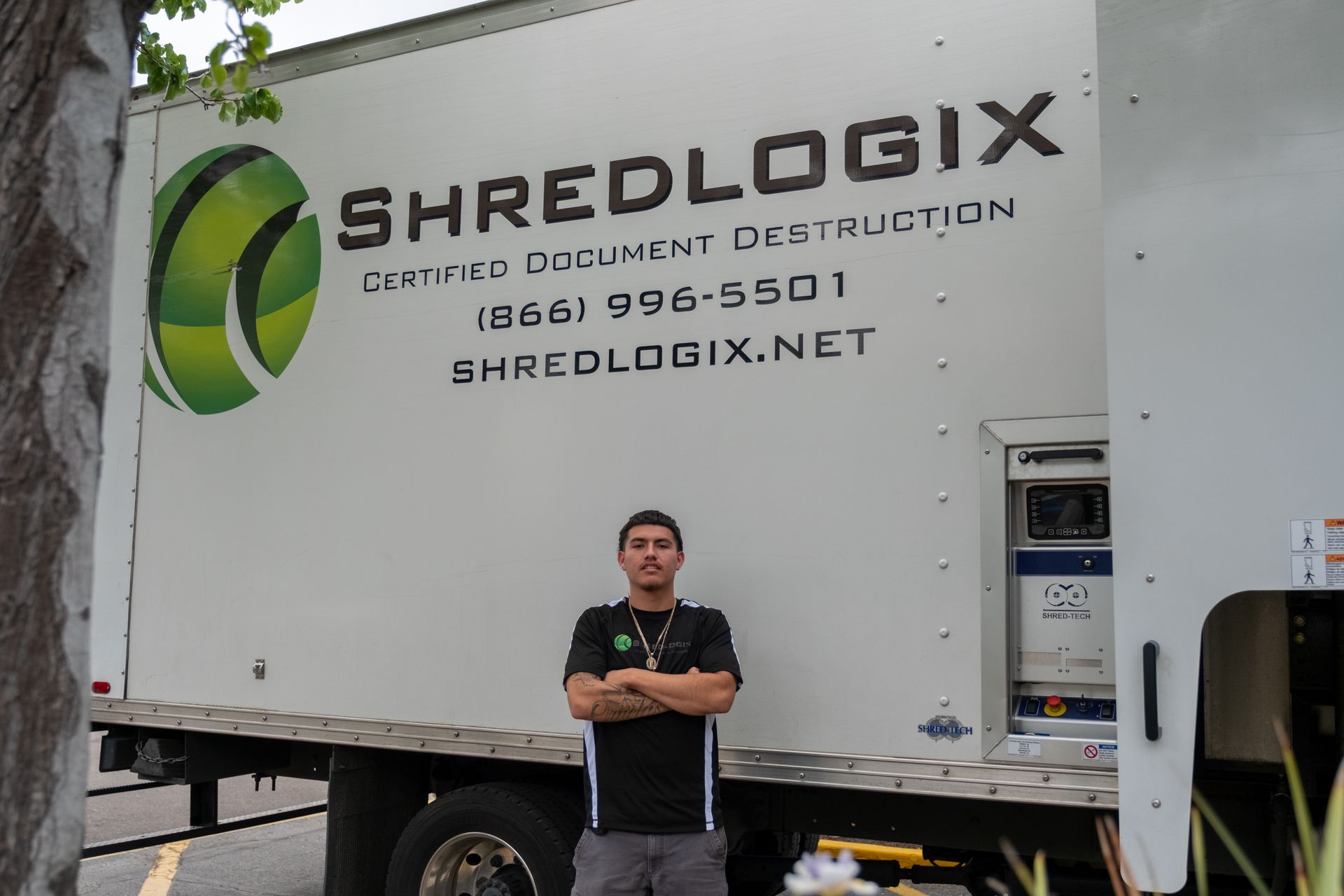 A man stands in front of a shredlogix truck