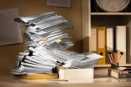 Stack of papers on desk, highlighting what documents should I shred.