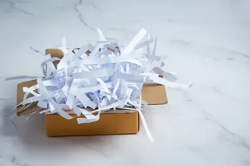 Shredded paper in a box symbolizing document shredding for remote workers.