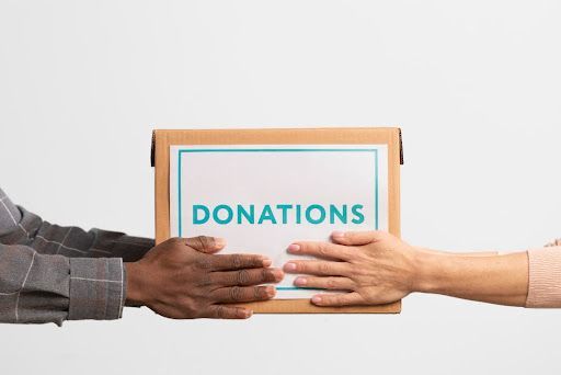 Two people exchanging a donation box, symbolizing secure Santa Rosa donor data shredding services to