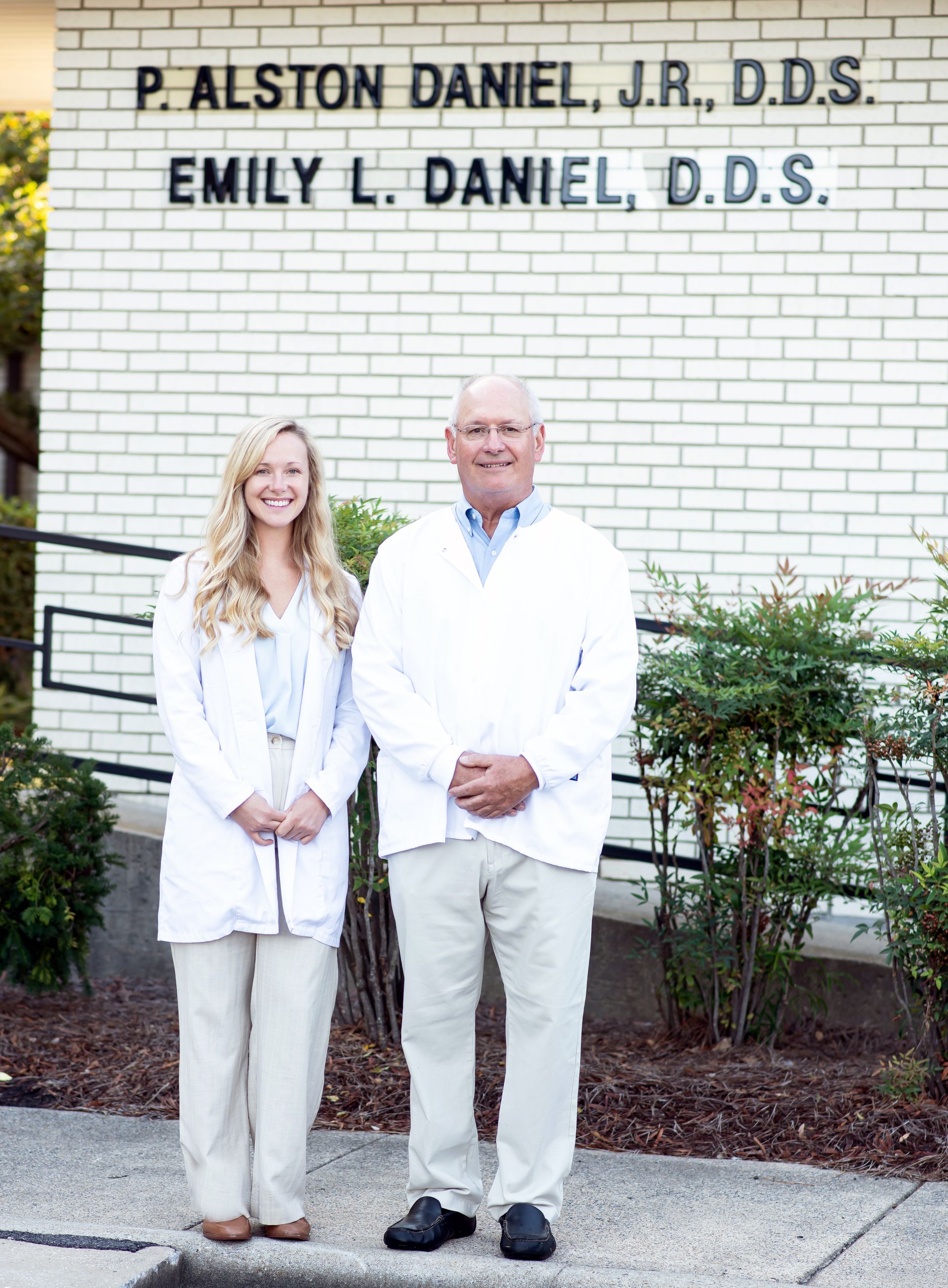 Two Doctors Are Standing In Front Of A Brick Building — Goldsboro, NC — P.A. Daniel Jr., D.D.S.