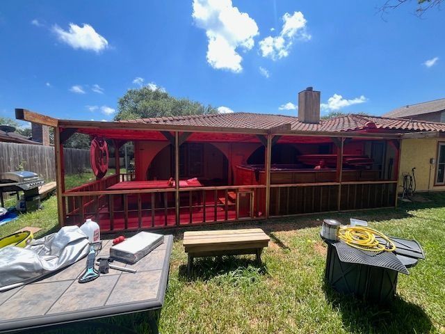A red gazebo in a backyard on a sunny day