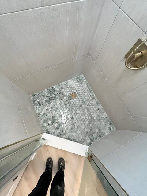 Person standing in a tiled shower