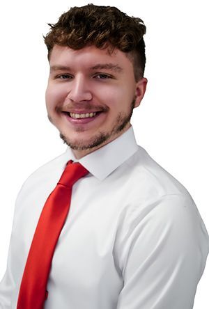 Man in white shirt and red tie smiling.
