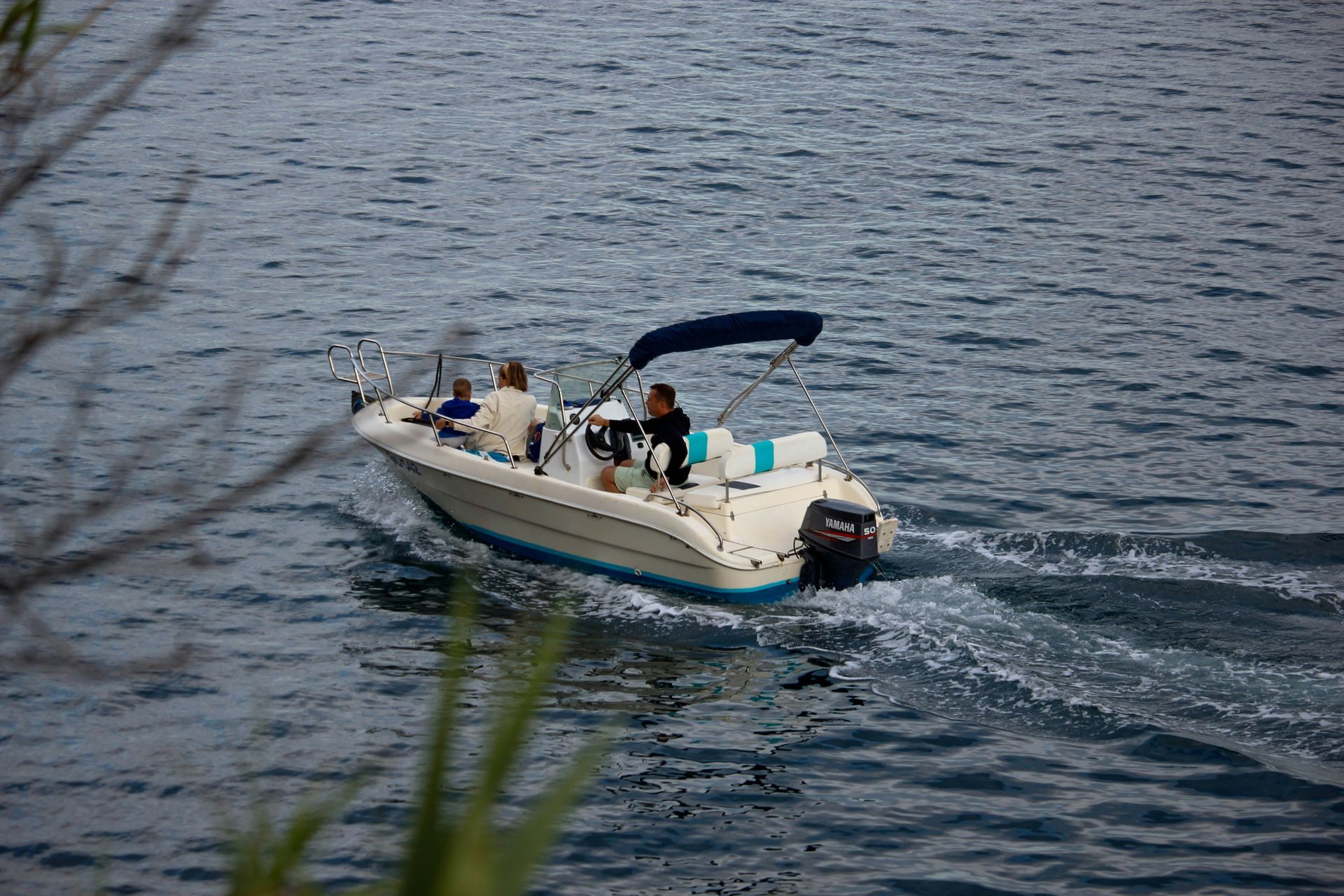 A man and a woman are loading boxes into the back of a car.