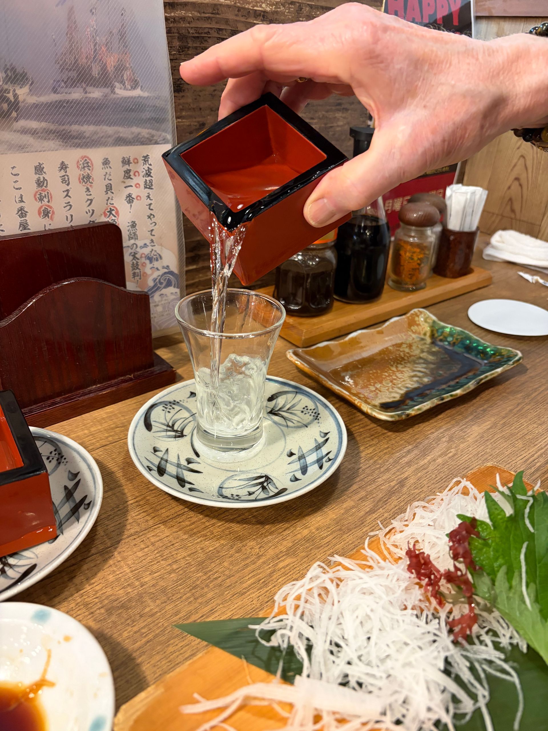 pouring sake from maze in glass