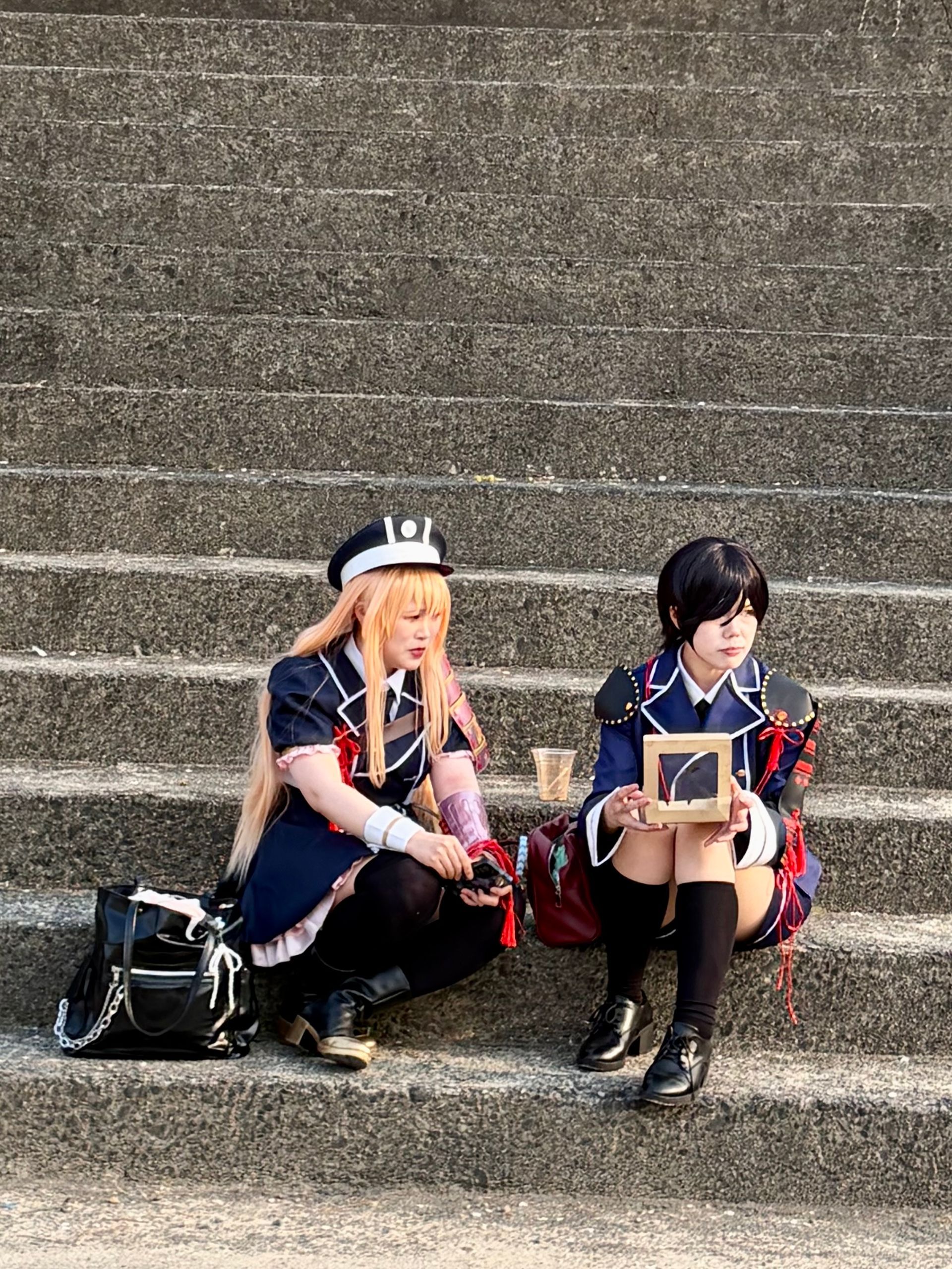 Cosplayers resting on the stone steps
