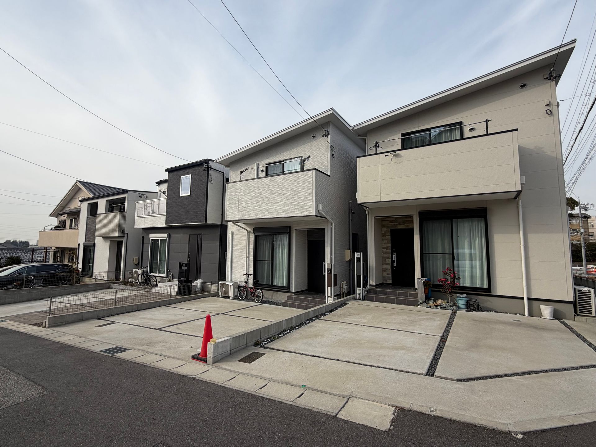 three prefab houses with parking places in front instead of gardens