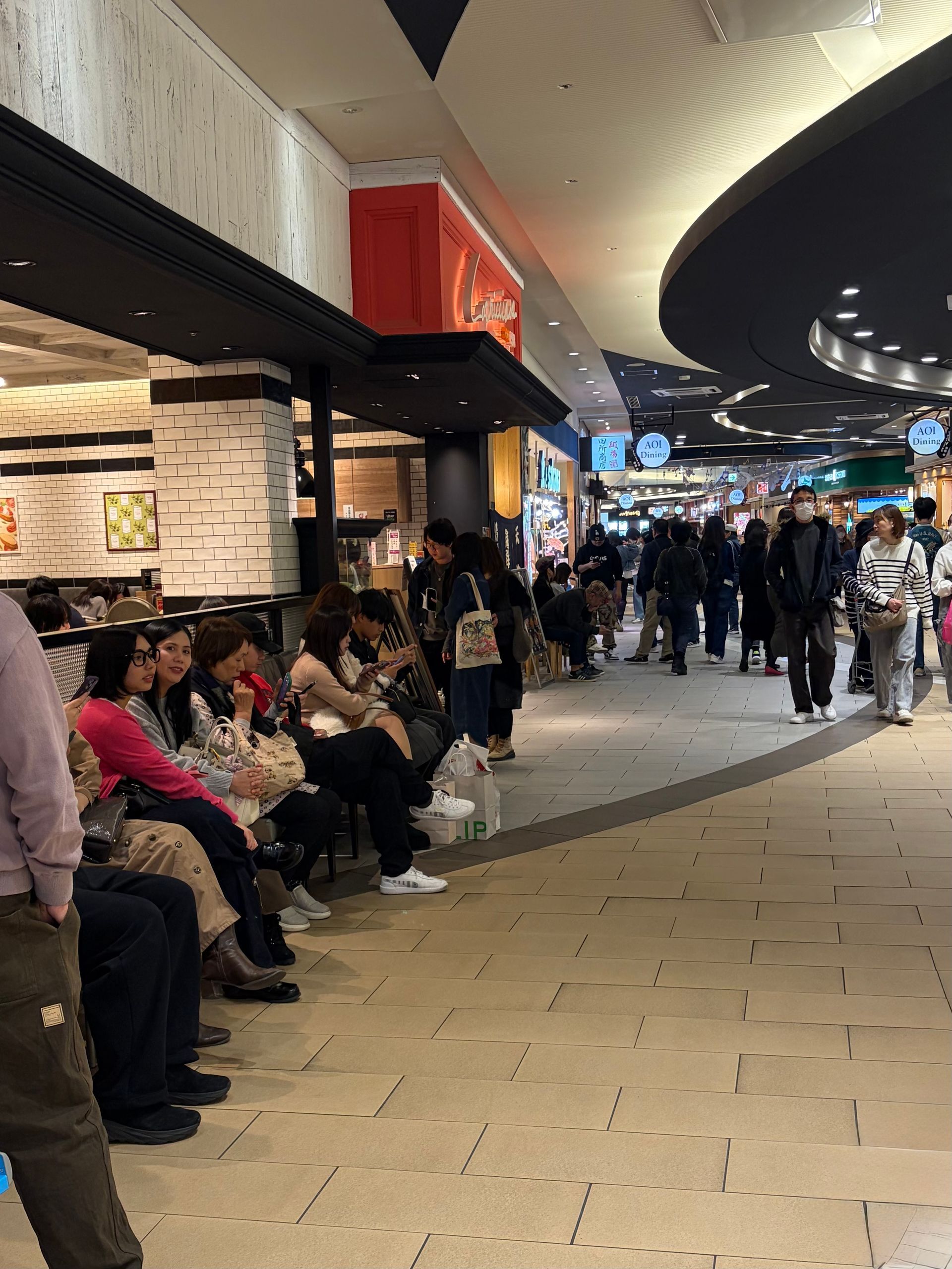 Aeon shopping center Okazaki. people in line on chairs waiting for their turn in restaurants