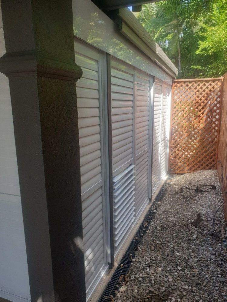 A Building with Shutters on The Windows and A Wooden Fence in The Background — Roll Edge In Manunda, QLD