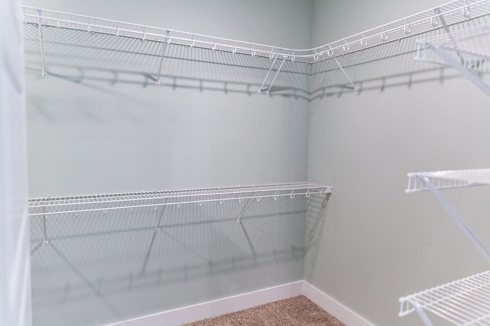 An Empty Walk In Closet With White Wire Shelves And A Carpeted Floor — Roll Edge In Manunda, QLD