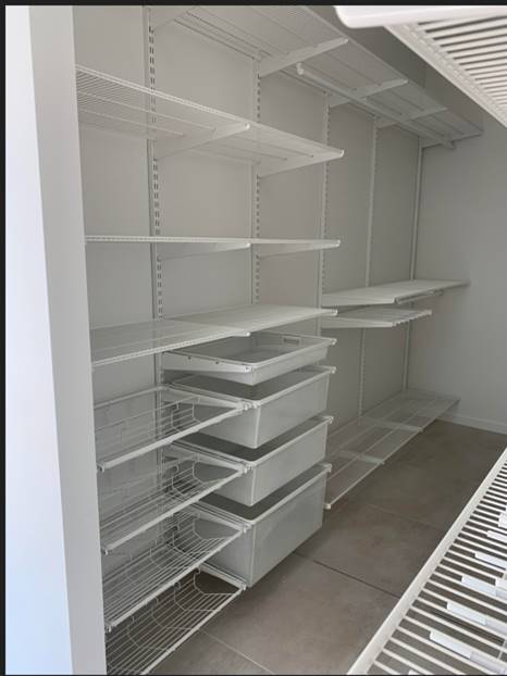 Empty white wire shelving system in a closet with solid shelves and pull-out drawers — Roll Edge In Manunda, QLD