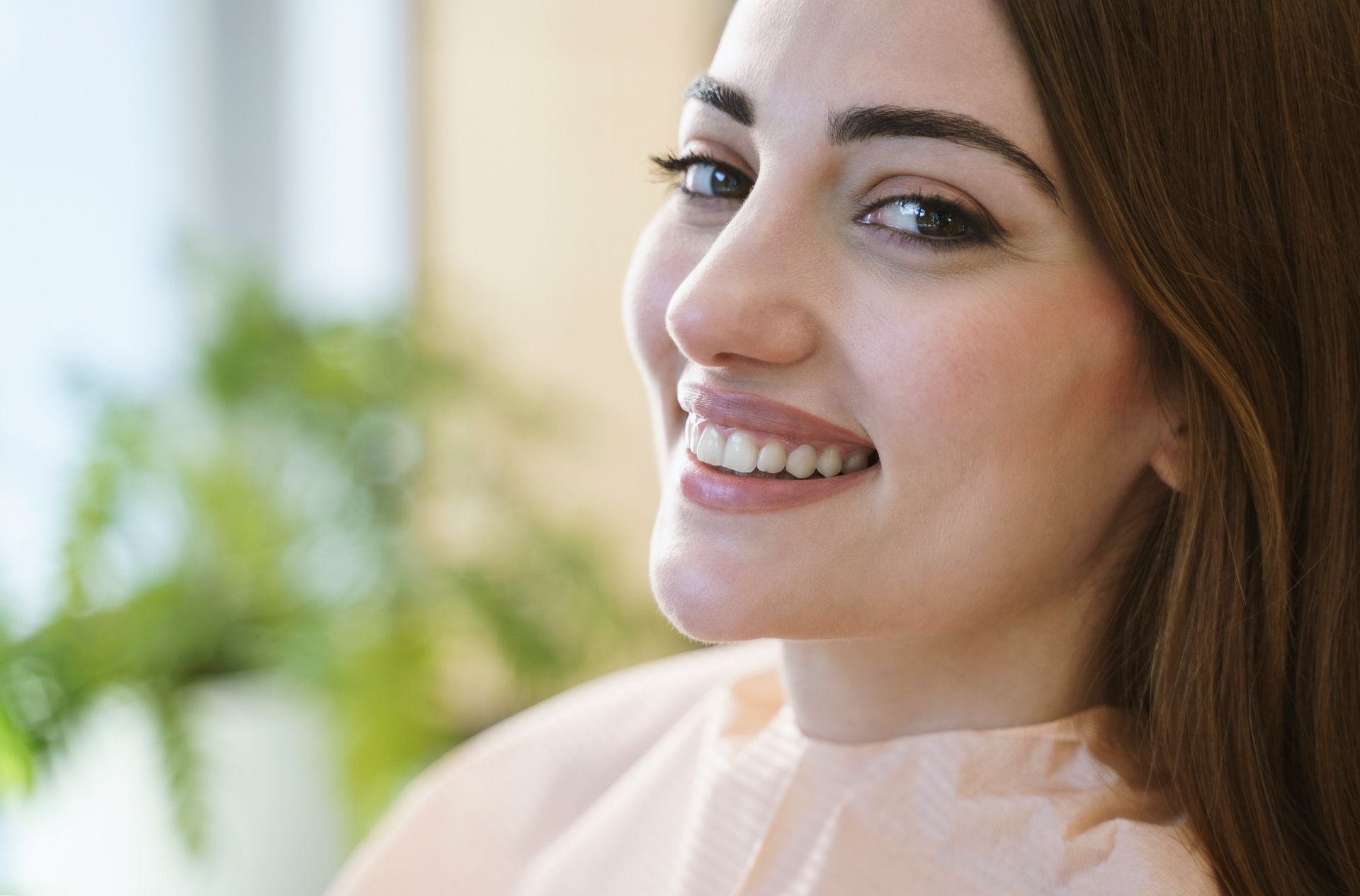 Close up portrait of a smiling pretty woman is receiving dental checkup.