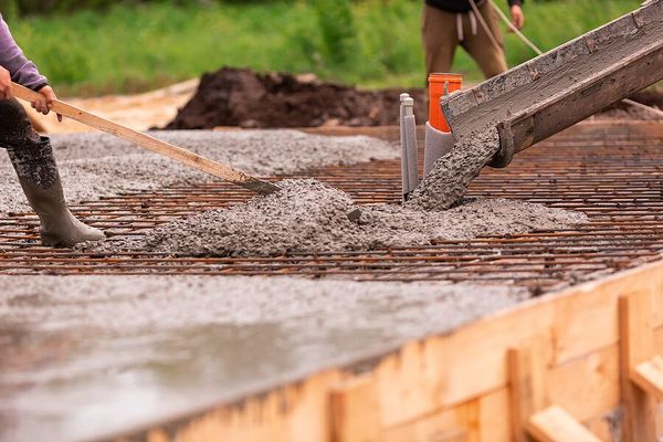 a man is pouring cement onto a construction site