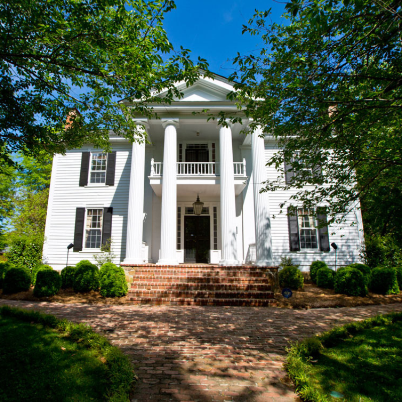 A large white house with columns and black shutters