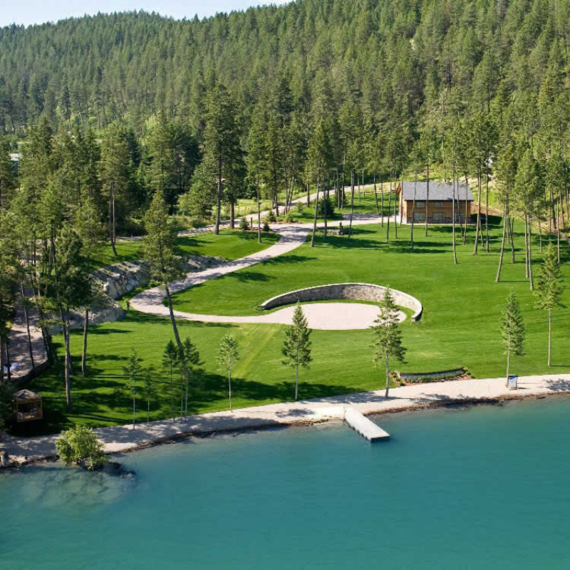 An aerial view of a lake surrounded by trees and grass