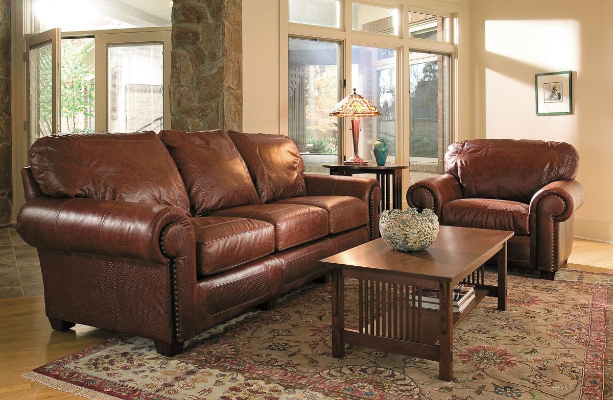 A living room with brown leather furniture and a coffee table