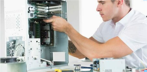 Picture of a computer technician cleaning a repairing a dismantles computer. The man is wearing a white shirt installing hardware.