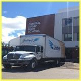 A white truck is parked in front of a building.