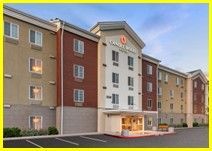 A large hotel with a lot of windows and a parking lot in front of it.