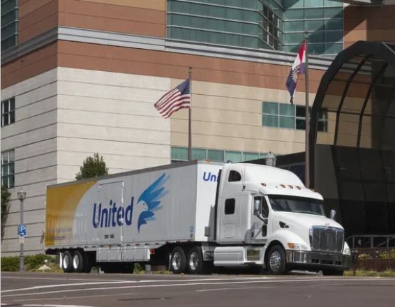 United truck parked in front of a building with flags.