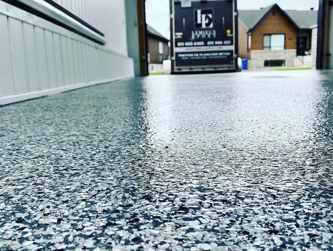 Un camion roule dans une allée à côté d'une maison.