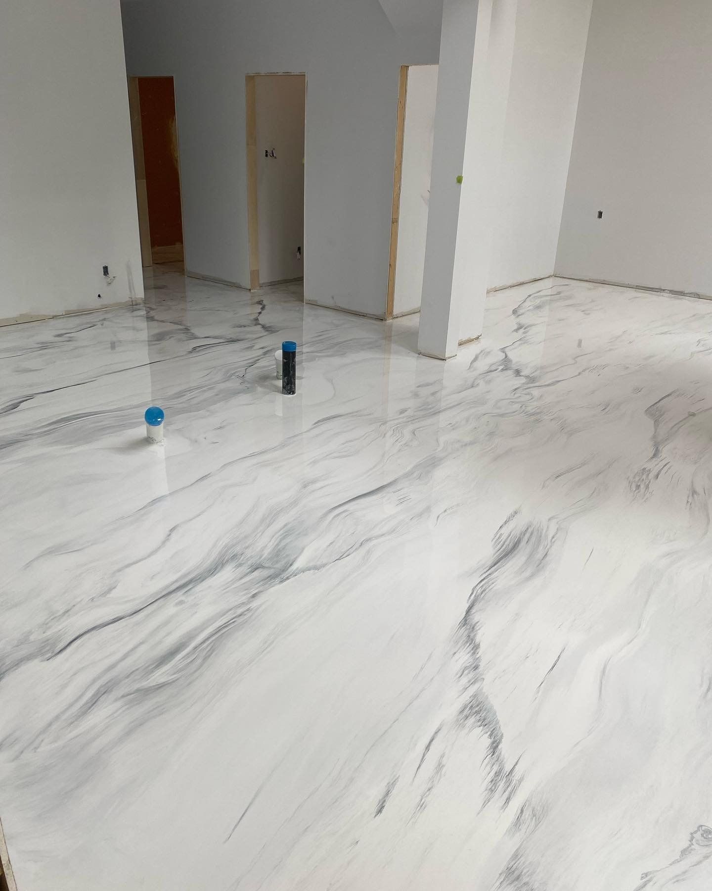Un sol en marbre blanc dans une pièce aux murs blancs.