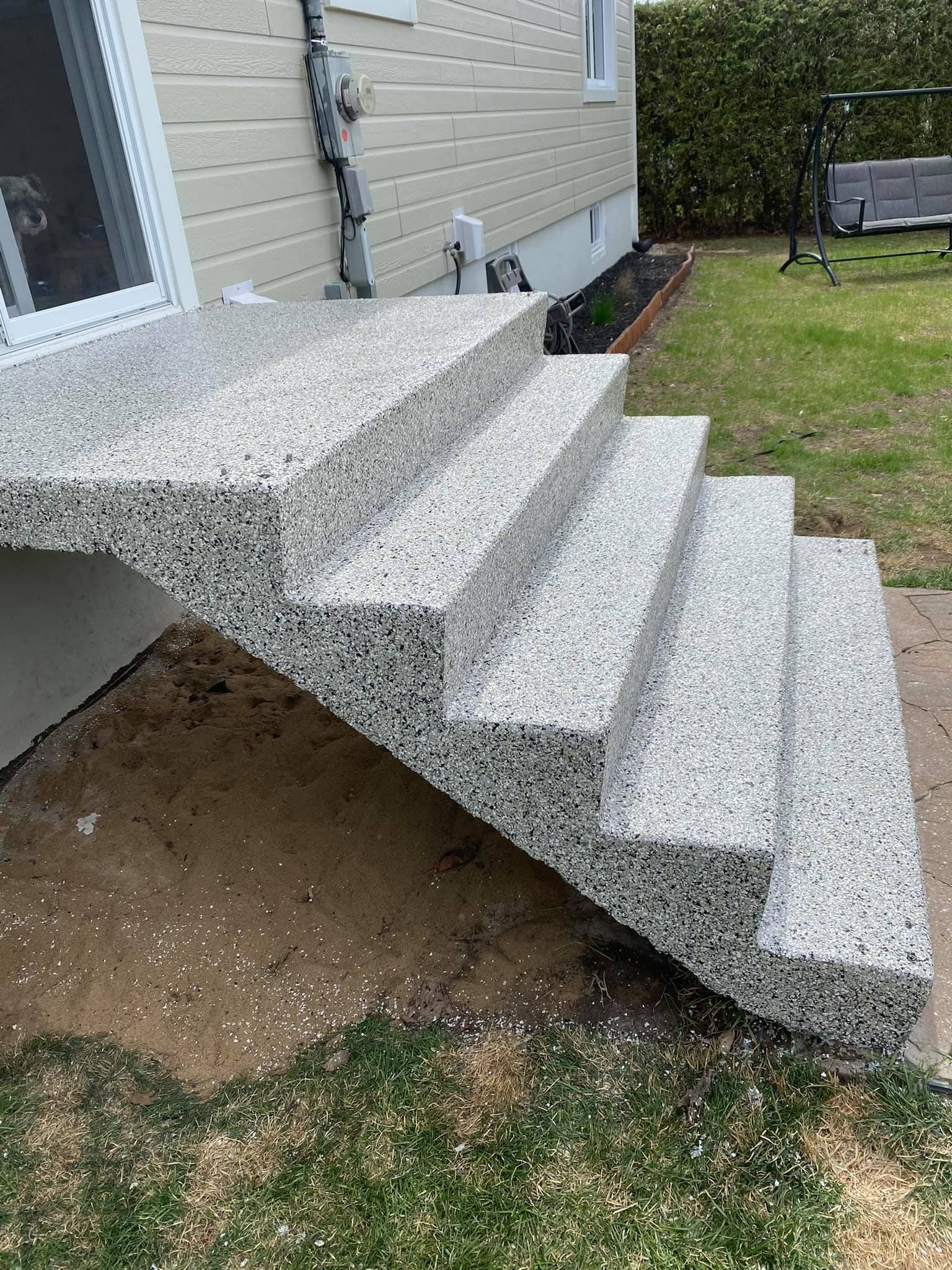 Un ensemble d'escaliers menant à une maison dans une cour arrière.