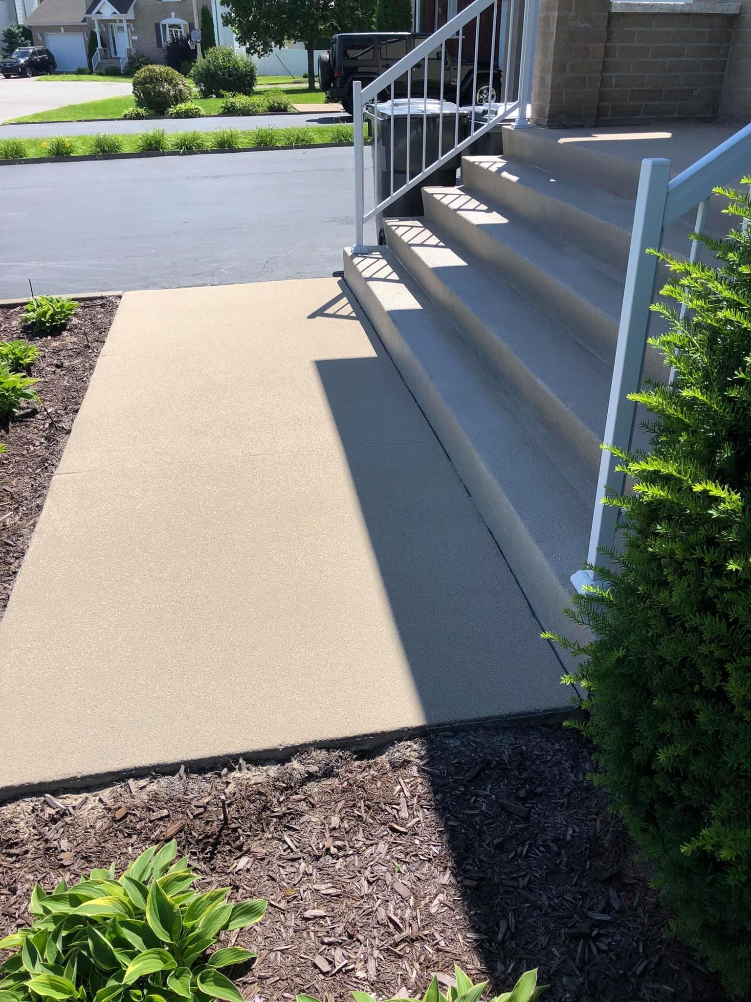Une passerelle en béton avec des escaliers menant à une maison.