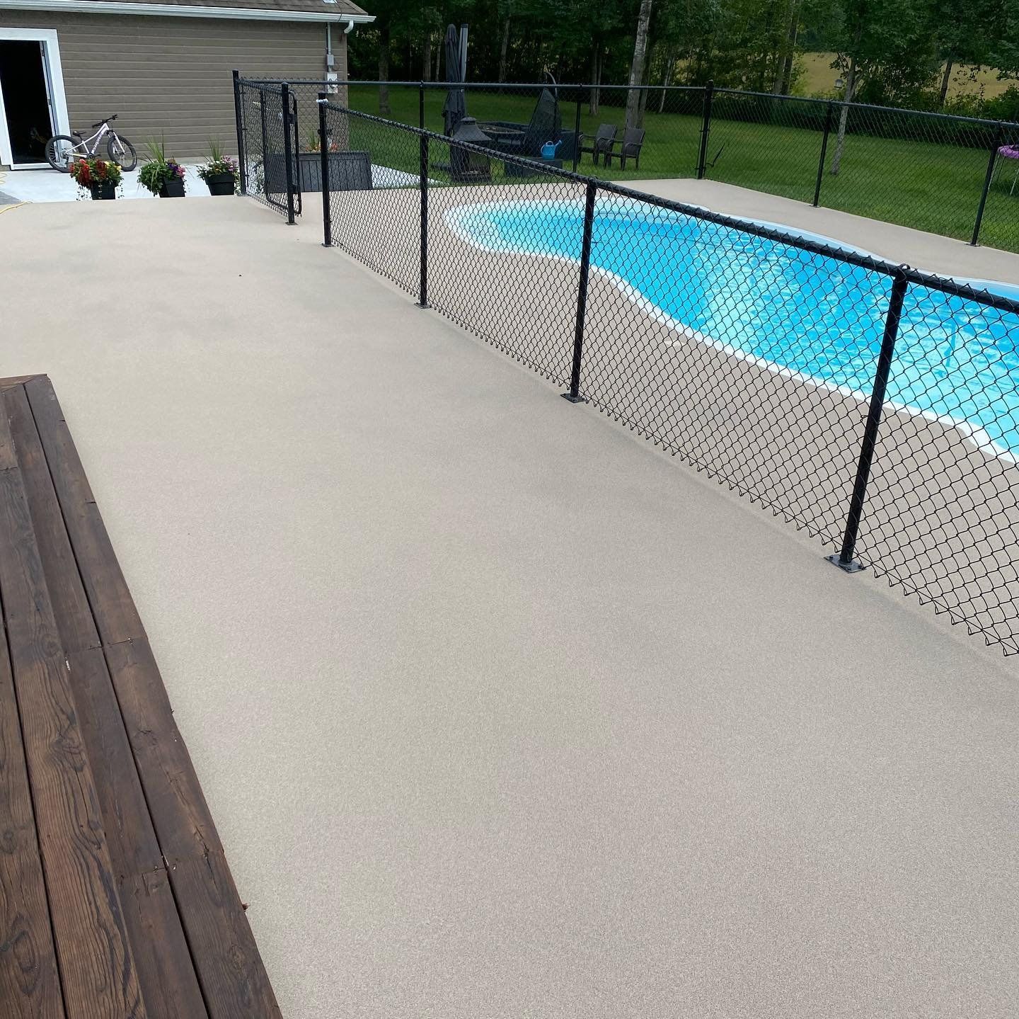 Une piscine entourée d'une clôture et d'une terrasse