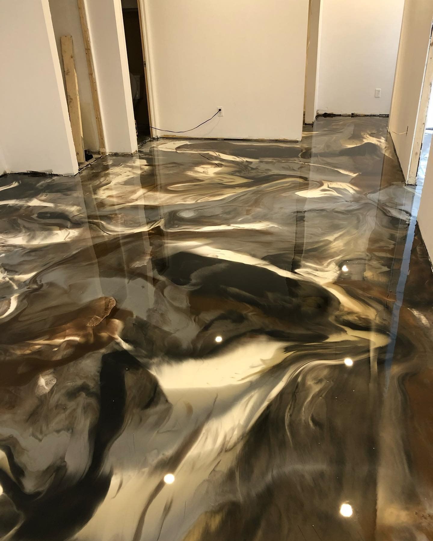 Un sol métallique brillant dans une pièce avec un motif en marbre.