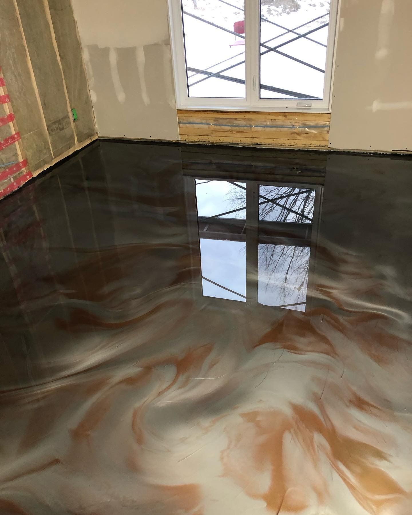 Une pièce avec un sol métallique brillant et une fenêtre.