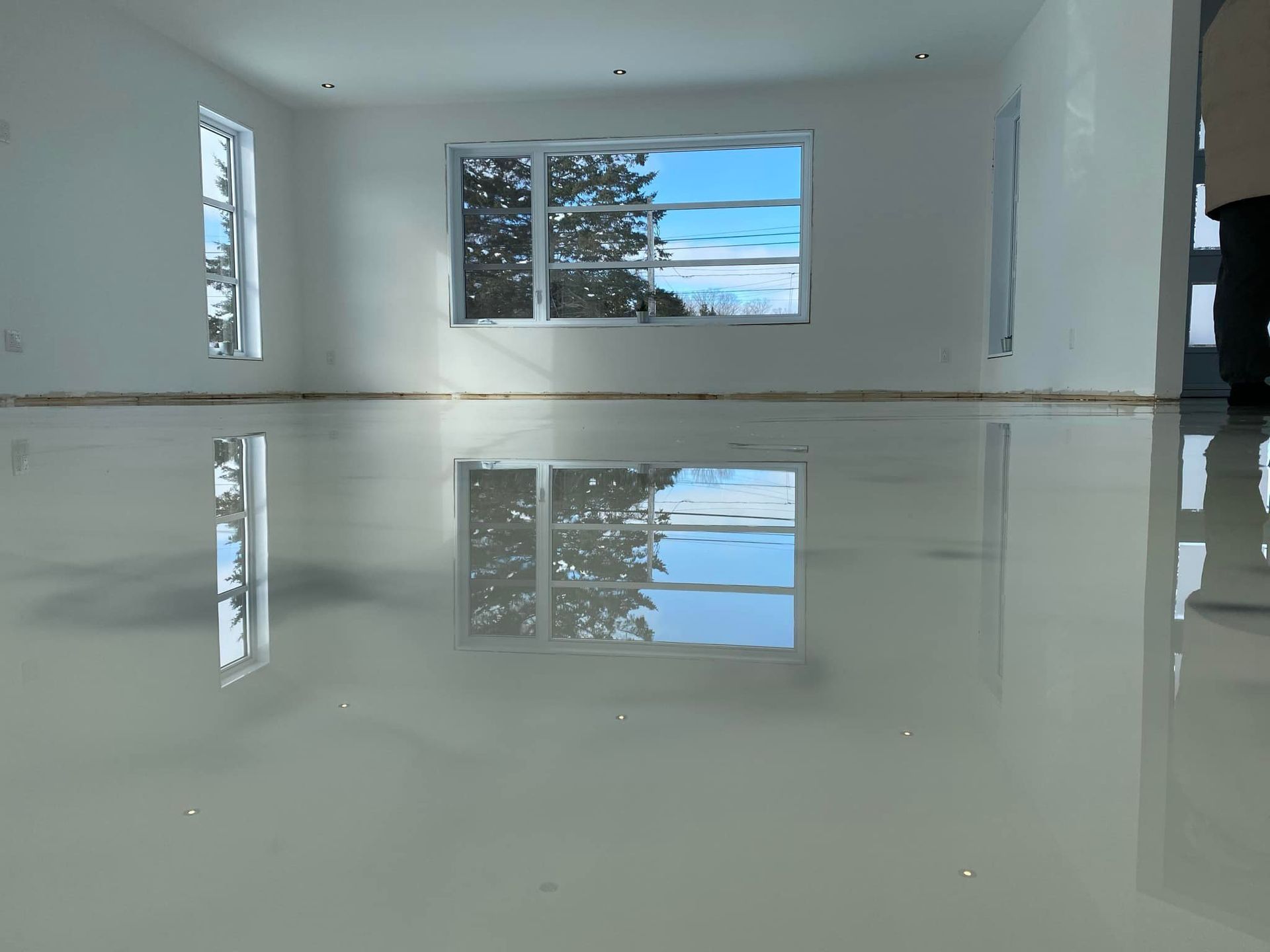 Une pièce vide avec un reflet d'arbres sur le sol