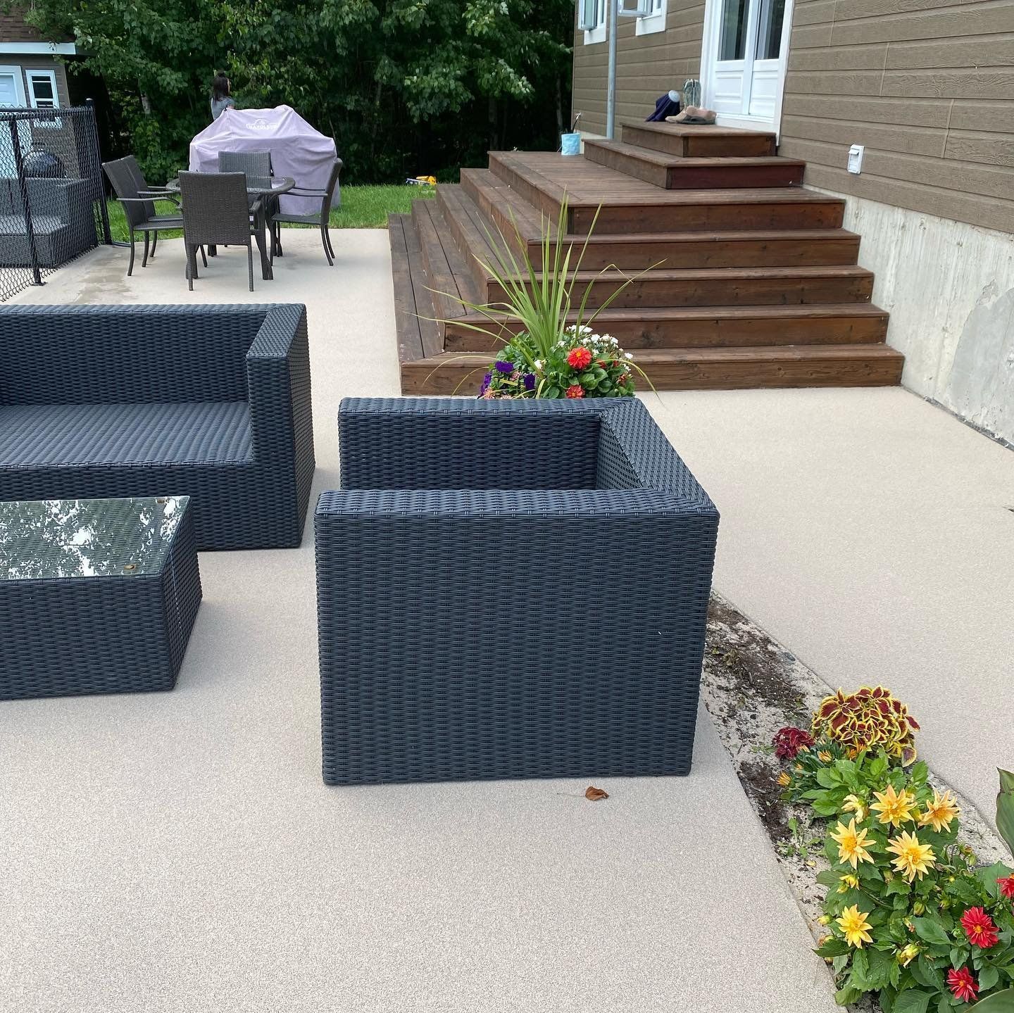 Un patio avec un canapé et des chaises devant une maison