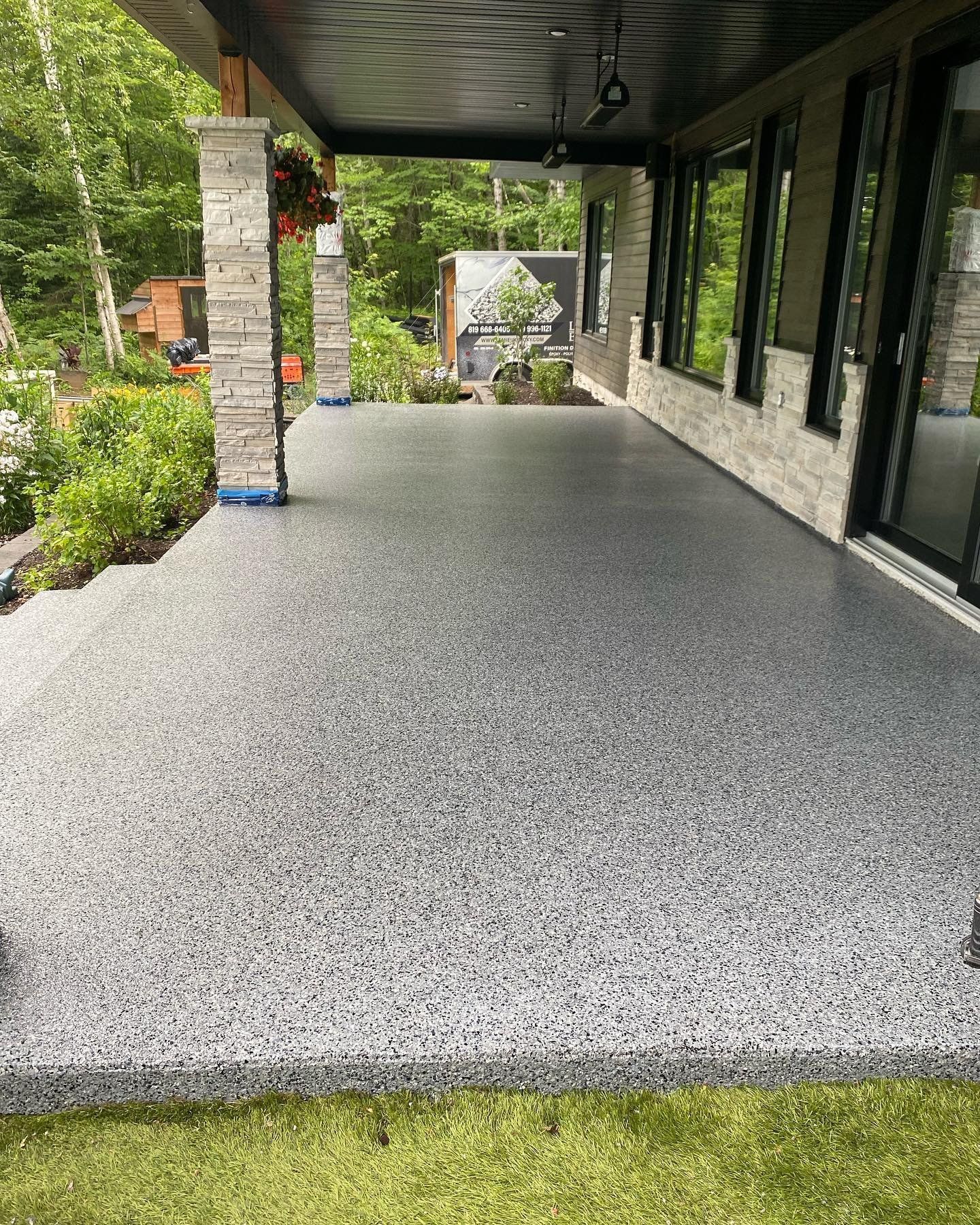 Un porche avec un sol en béton et un toit.