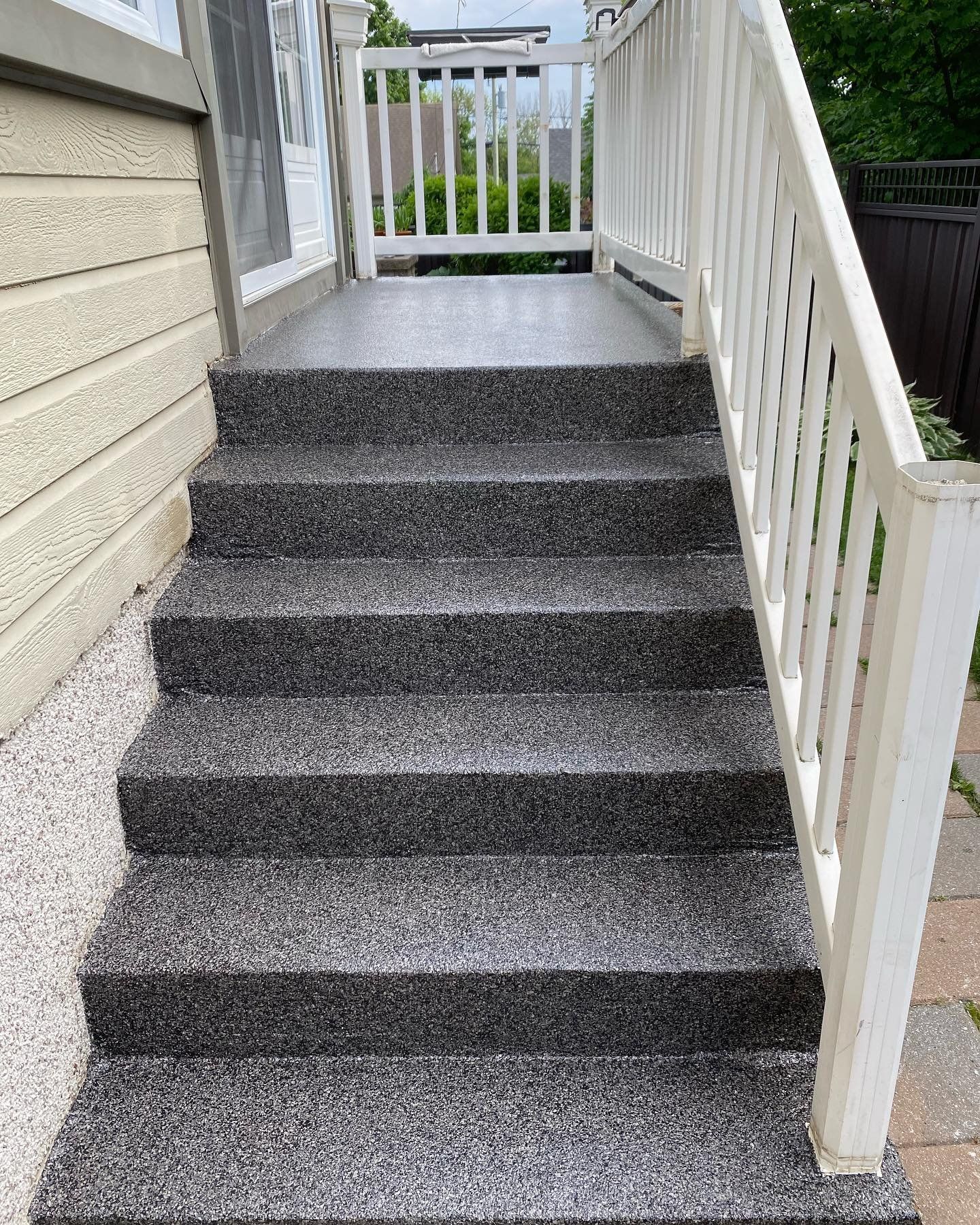 Un ensemble d'escaliers menant à un porche avec une balustrade blanche.