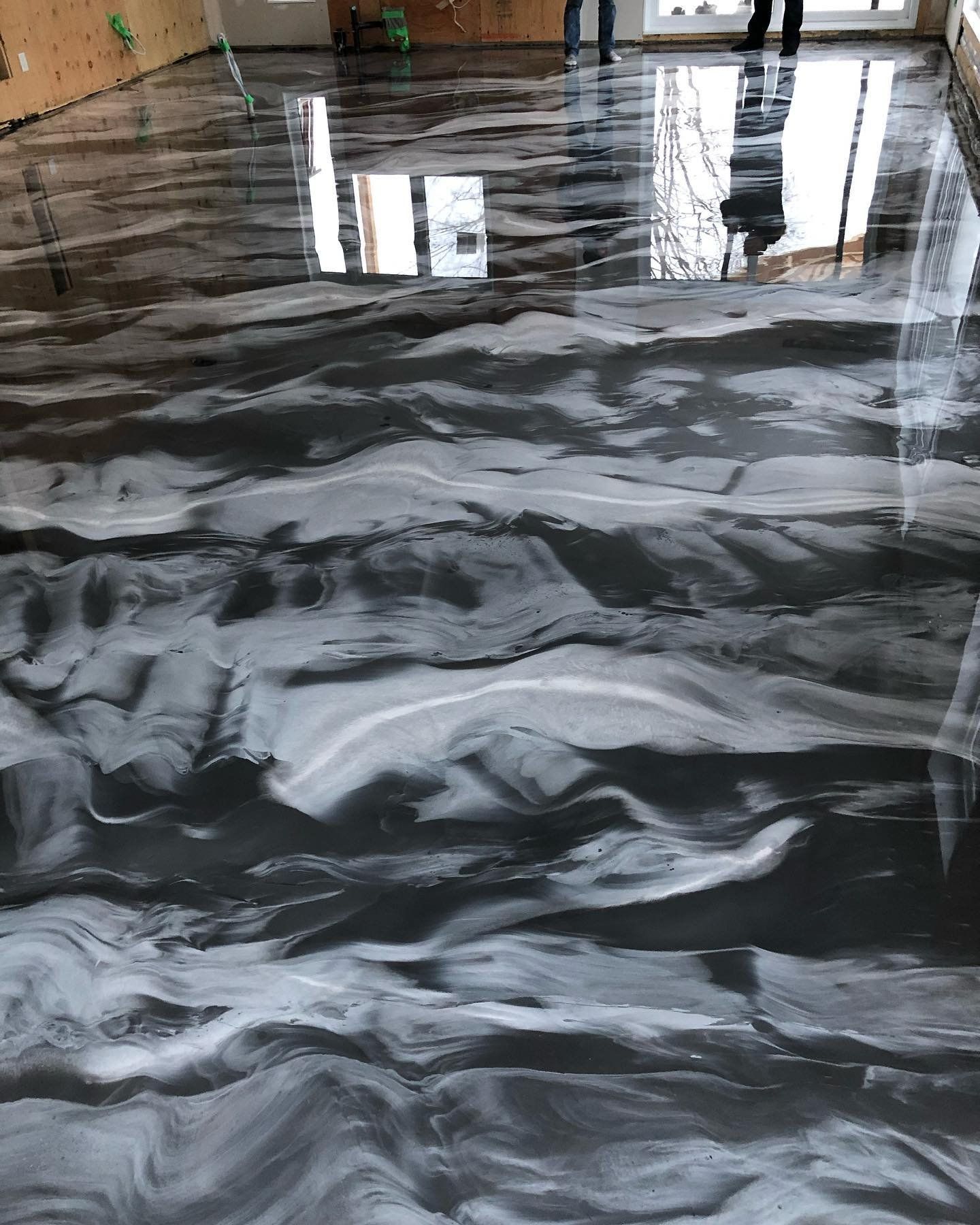 Un sol en marbre noir et blanc avec le reflet d'un bâtiment à l'intérieur.