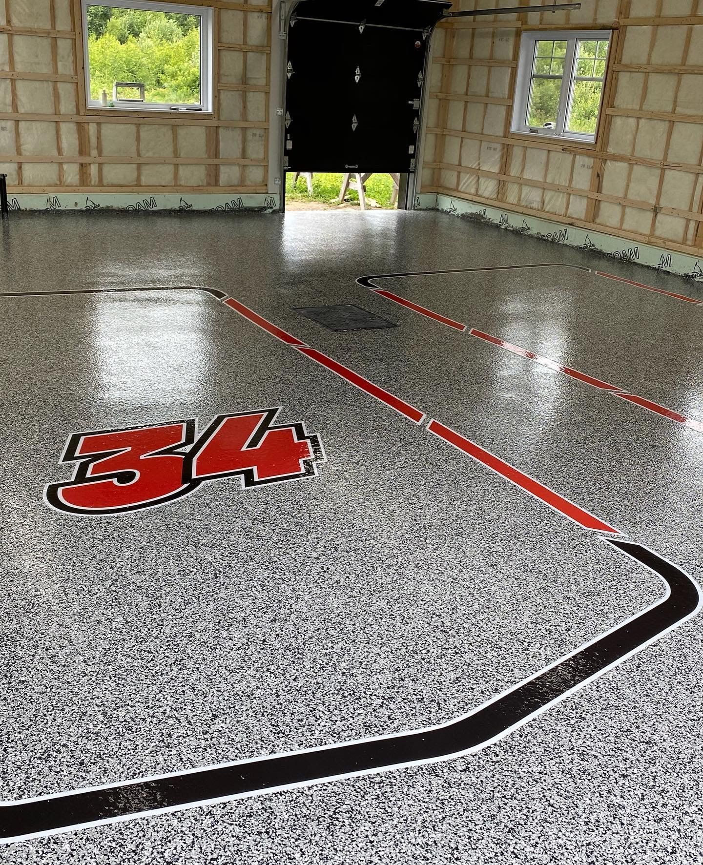 Un garage avec un sol de couleur grise et rouge et une ligne noire sur le sol.