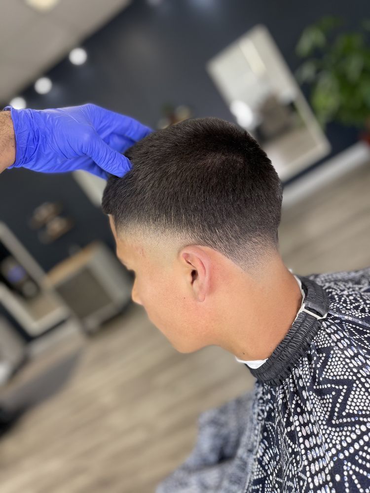 A man is getting his hair cut by a barber in a barber shop.