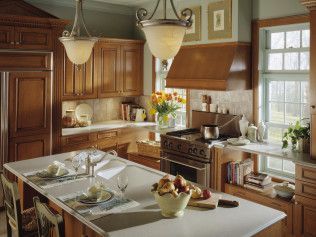 A kitchen with wooden cabinets , stainless steel appliances , and a large island.