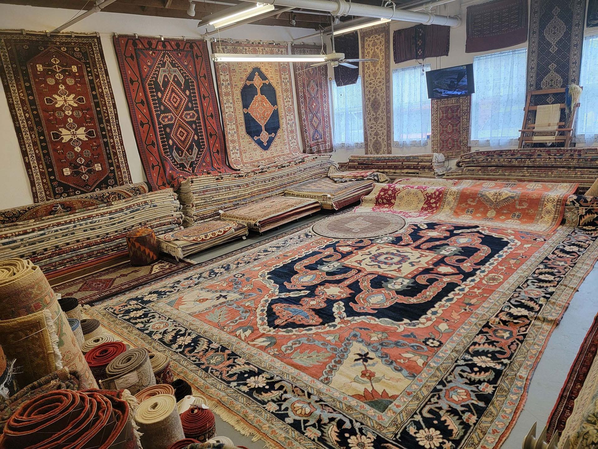 a room filled with lots of rugs and carpets.