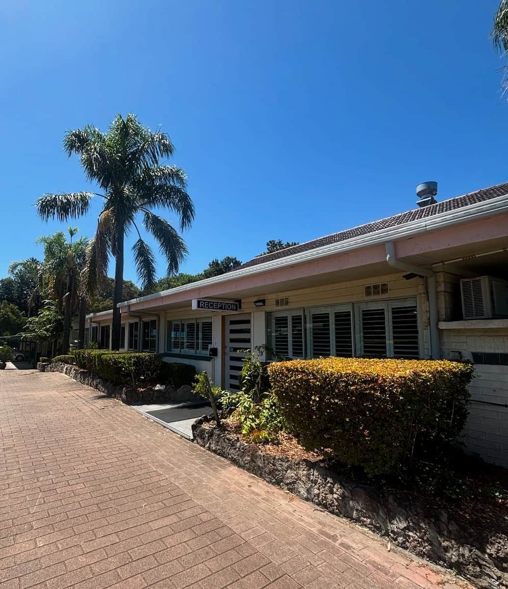 A Low-rise, Beige-walled Building With Window Shutters — Crystal Clear Plumbing & Roofing in Albion Park, NSW