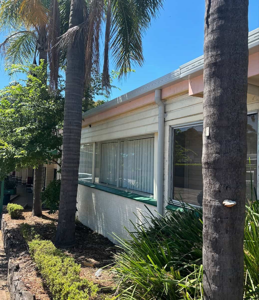 A Light-colored Building With Large Windows — Crystal Clear Plumbing & Roofing in Fairy Meadow, NSW