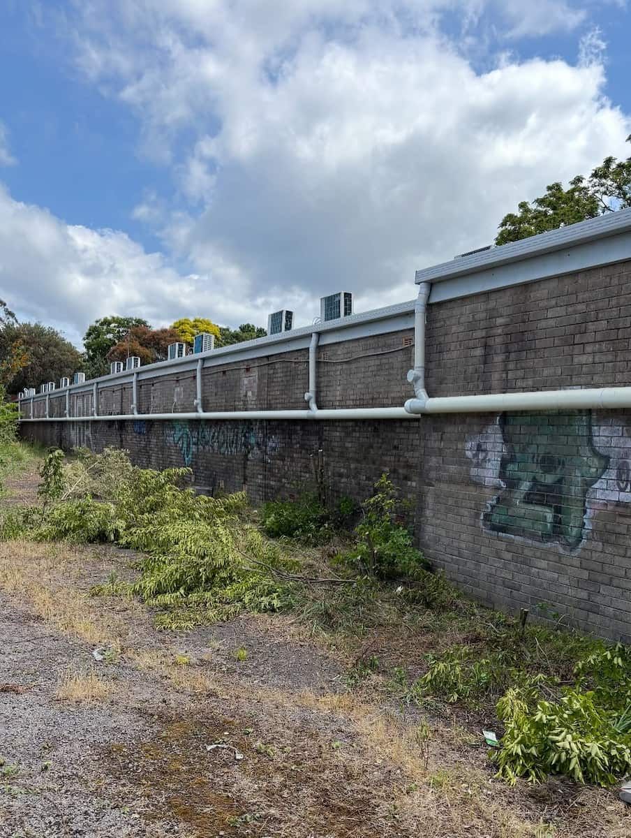 A Long Brick Wall Under a Blue Sky, Featuring a Horizontal — Crystal Clear Plumbing & Roofing in Wollongong, NSW