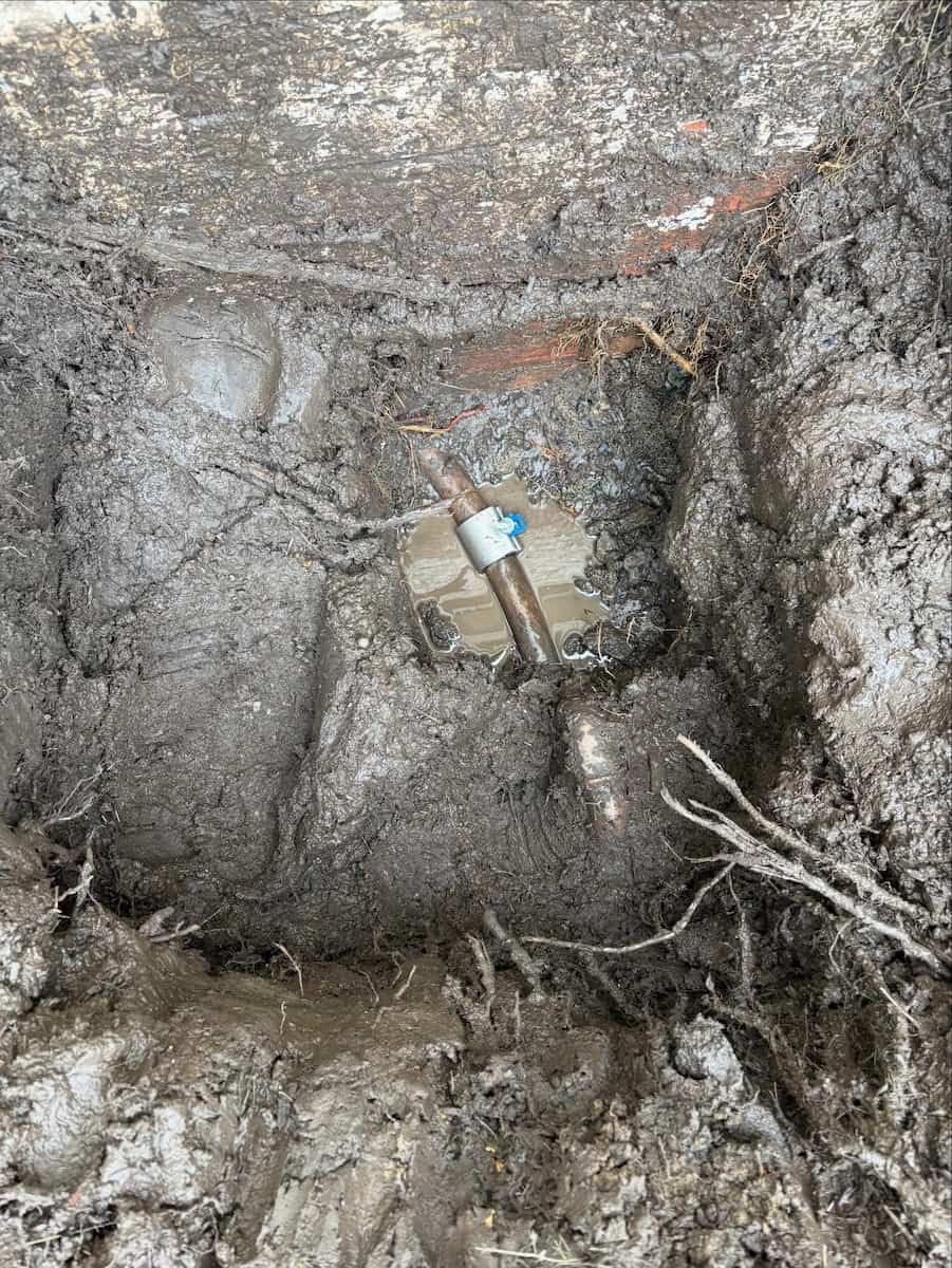 A Metal Pipe Coupling Connects Two Sections of a Pipe Buried in Dark — Crystal Clear Plumbing & Roofing in Wollongong, NSW