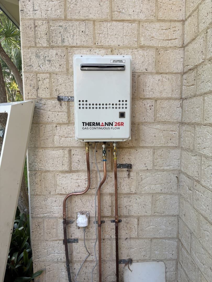 A White Thermann 20L Continuous Flow Gas Water Heater Mounted — Crystal Clear Plumbing & Roofing in Wollongong, NSW